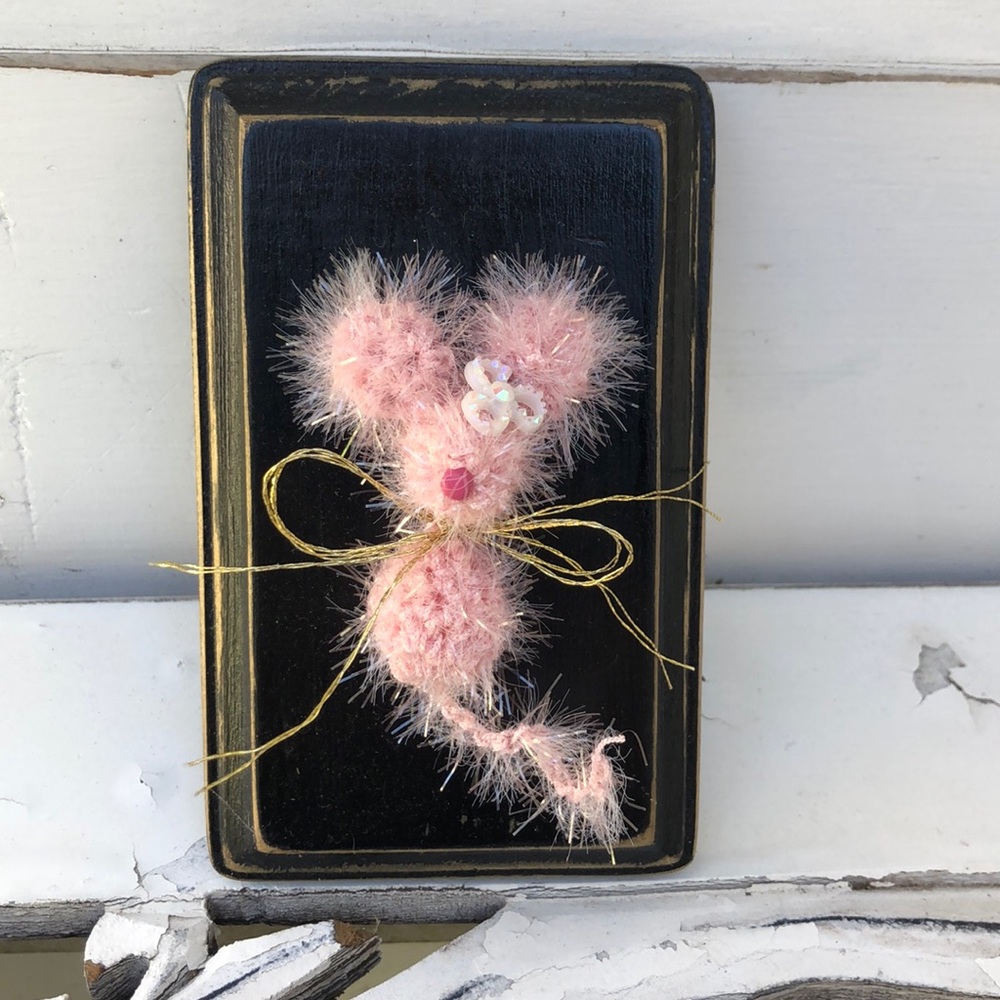 Crocheted tiny mouse on a wood plaque